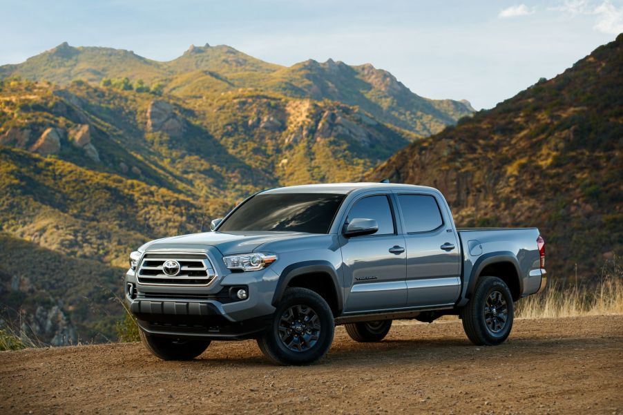 A silver 2021 Toyota Tacoma midsize truck in a desert mountainous area.