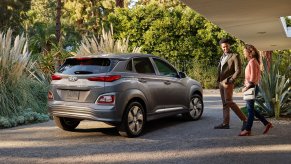 A couple walks toward their beige 2021 Hyundai Kona Electric.