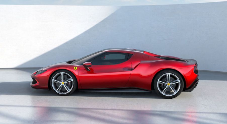 A red 2022 Ferrari 296 GTB sports car parked on a white floor in front of a white wall