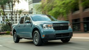 A light-blue 2022 Ford Maverick XLT Hybrid drives down a city street