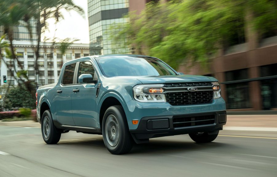 A light-blue 2022 Ford Maverick XLT Hybrid drives down a city street