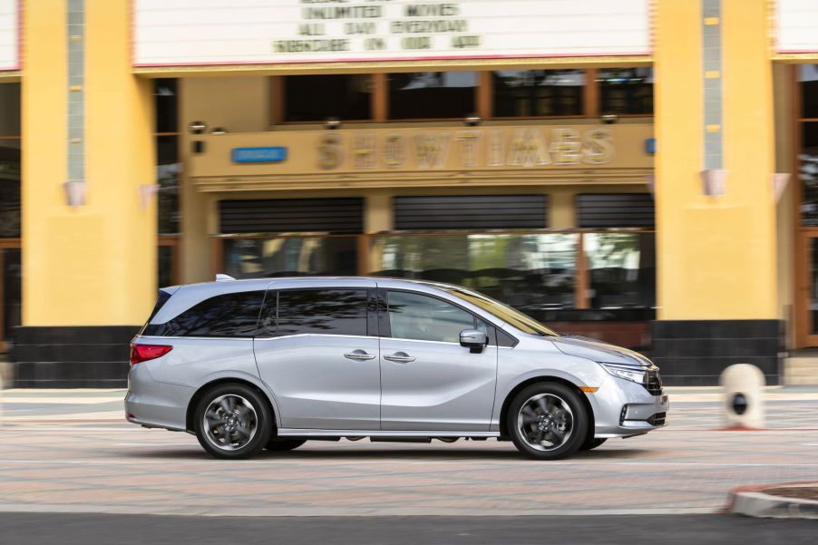 A gray 2022 Honda Odyssey minivan driving past a movie theater