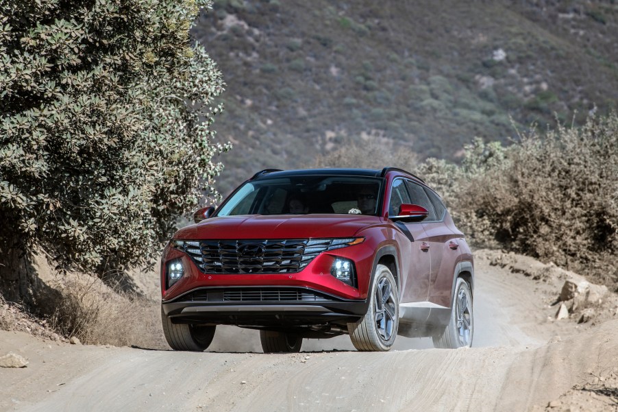 A dark-red metallic 2022 Hyundai Tucson compact SUV parked on a dusty mountain road