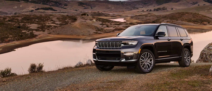 The 2022 Jeep Grand Cherokee L SUV model parked on a hill near a river