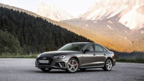 A 2021 Audi A4 Sedan model parked on an asphalt lot near a forest and mountain range