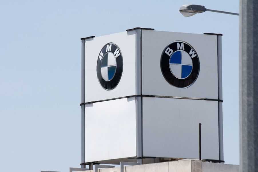 A white BMW marquee tower with BMW's logo shown on the two sides of the marquee visible with a clear sky in the background.