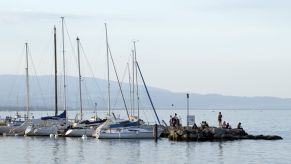 A row of sail boats anchored in the middle of a lake