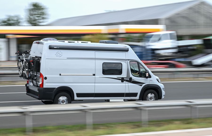 A campervan driving down the highway with a blurred background.