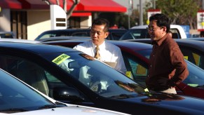 Two men on a car dealership lot