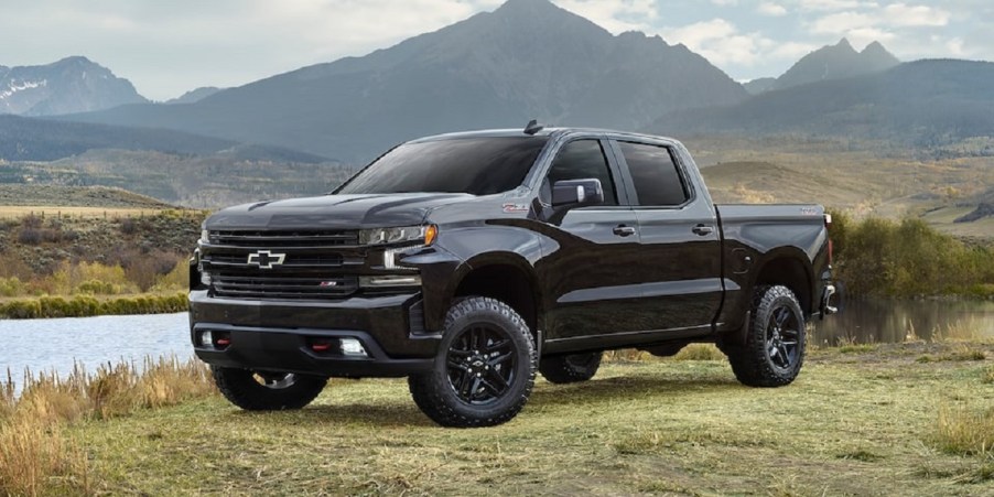 A black 2021 Chevy Silverado parked next to a lake.