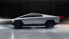 A silver Tesla Cybertruck against a black and smoky background.