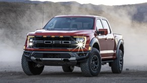 A red 2021 Ford F-150 on a gravel road.