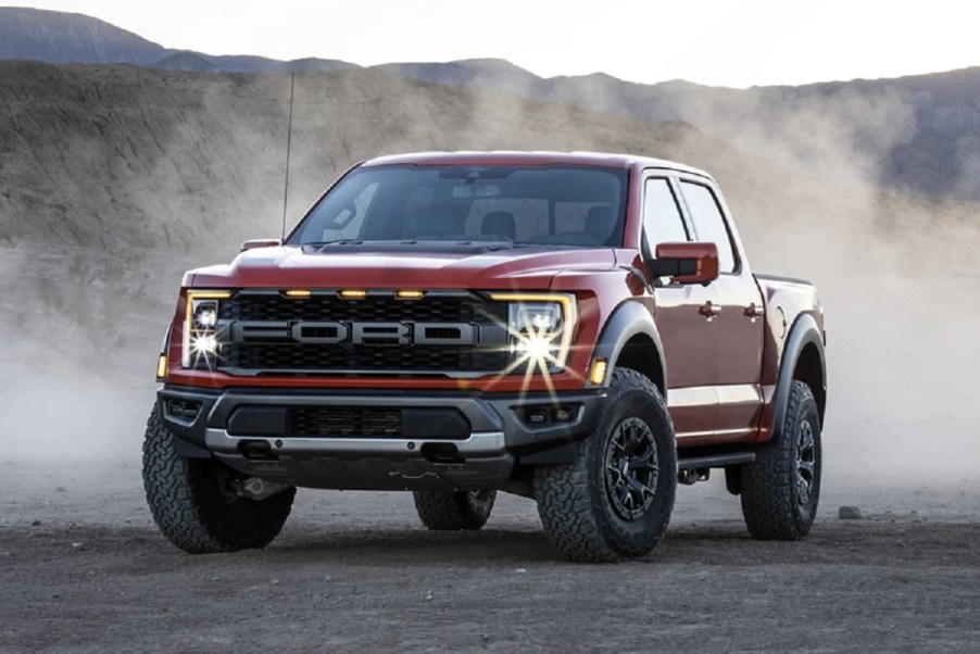 A red 2021 Ford F-150 on a gravel road.