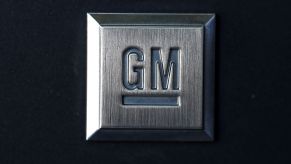 A charcoal grey plaque with the General Motors logo, GM, on it against a black background.