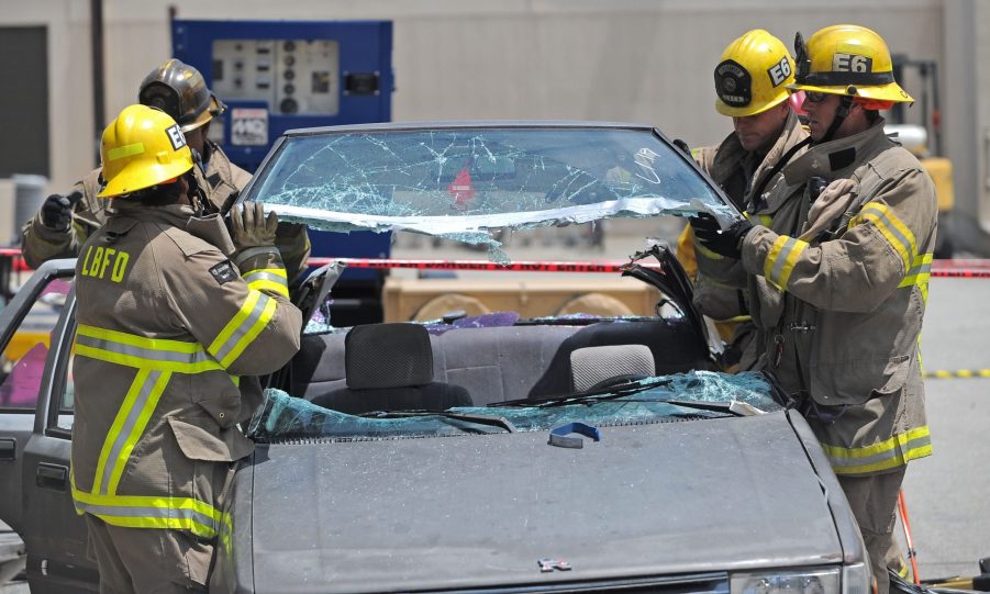 A group of firefighters cut the roof off of a crashed car