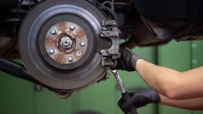 A mechanic performs a brake job in a shop