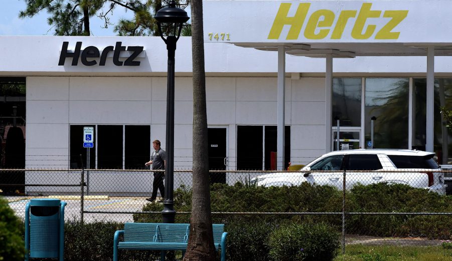 A Hertz rental car agency with palm trees in the foreground