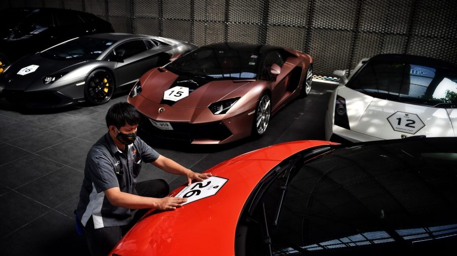 A man applies a vinyl wrap to a vehicle in Thailand