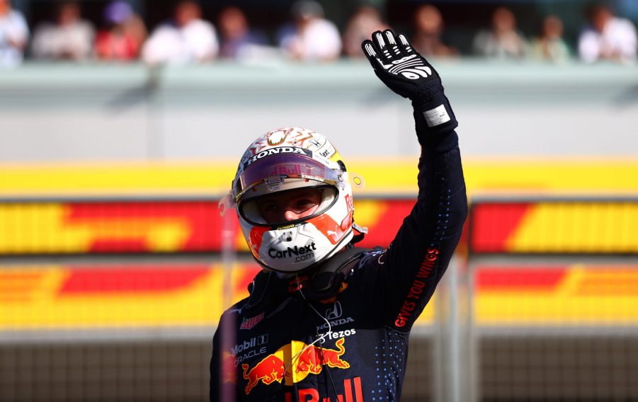 Max Verstappen waves to the crowd at Silverstone, helmet on