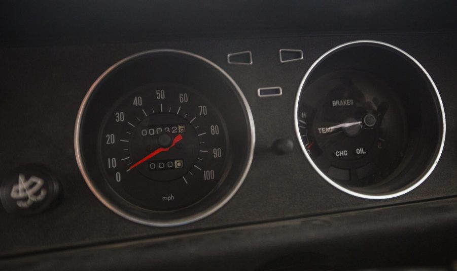 An odometer on an older car, showing lower mileage