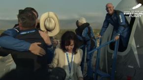 Jeff Bezos coming off the rocket New Shepherd with his crew dressed in space suits.