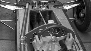 Jim Clark with his feet on two of the Lotus 25 F1 car's three pedals at the 1962 Grand Prix of Belgium