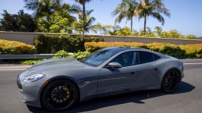 The Karma GS-6 luxury sports car driving near palm trees