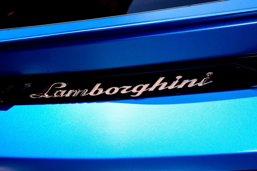 Close shot of the back of a blue Lamborghini displaying the full name of the car.