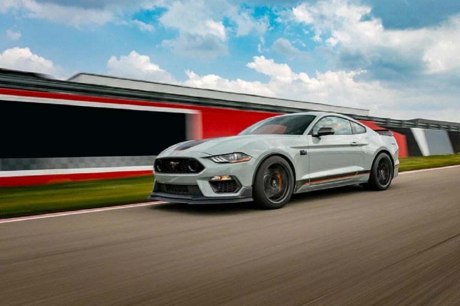 A light-colored 2021 Ford Mach-E races along a track.