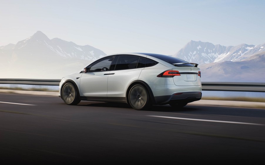 A white 2021 Tesla Model X drives down a highway.