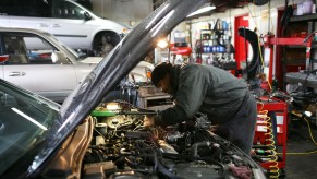 A mechanic under the hood of a car