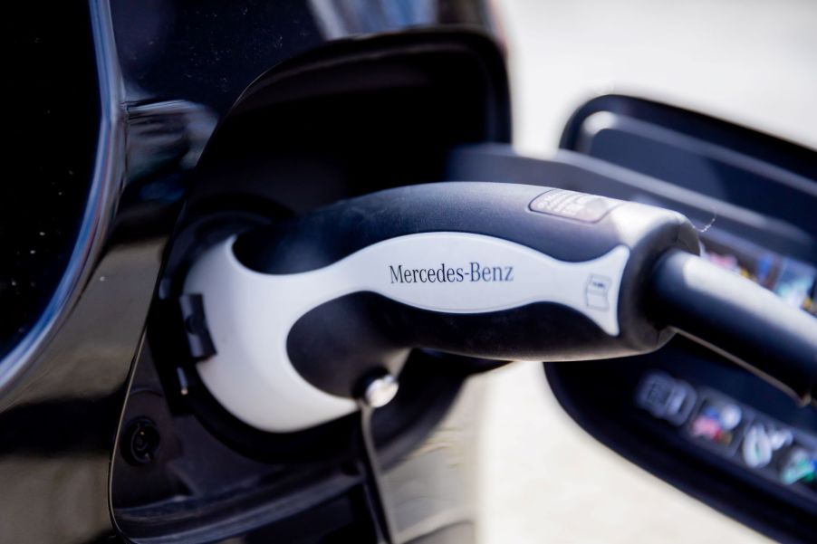 A Mercedes charger plugged into a black car.