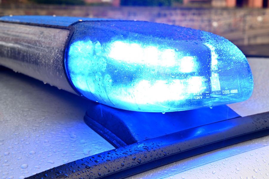 A blue flashing roof light on top of a police car