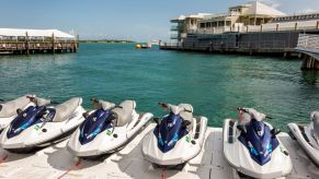 A row of rental jet skis on a marina