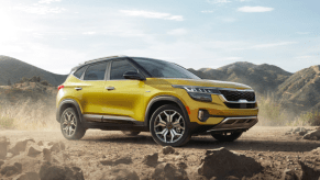 A yellow 2022 Kia Seltos parked in sand