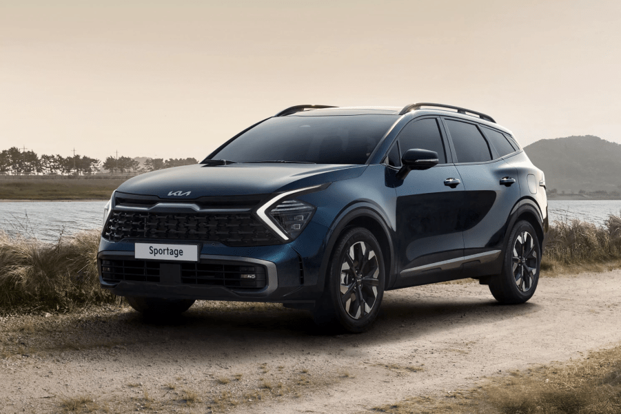 A dark colored 2023 Kia Sportage parked in sand