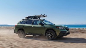 A 2021 Subaru Outback with surfboards strapped to it.