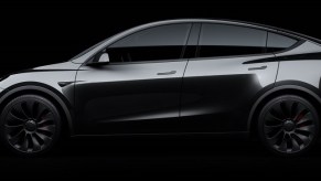 A dark gray Tesla Model Y against a black background.