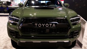 An army green 2021 toyota tacoma TRD Pro grille on display at an auto show