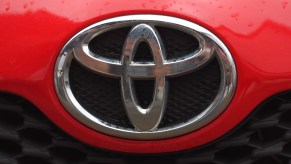 A silver Toyota logo on the front of a red vehicle