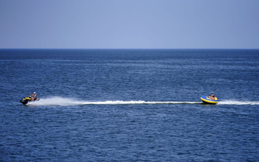 A tube being towed across the water from a jet ski