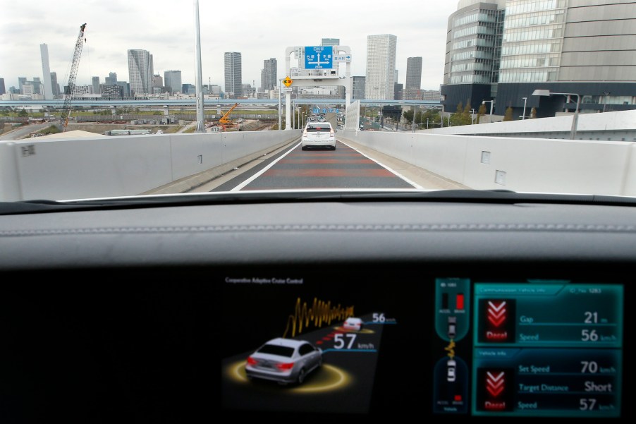 A view through a Lexus car's windshield as a monitor displays the status of the adaptive cruise contro