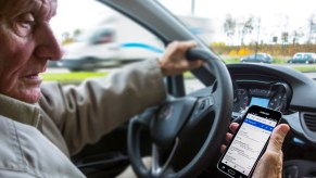 Scary driving habits including checking your phone messages while driving, like this man sitting behind the wheel of a car