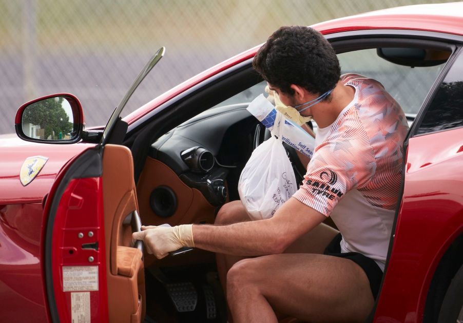 A man opens the door to his car with his left hand