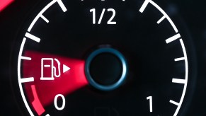 A car's fuel gauge points toward empty