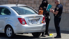 A California Highway Patrol officer and a crime scene investigator at the scene of a deadly road rage incident on May 21, 2021