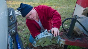 A man hitches a horse trailer to a trailer hitch