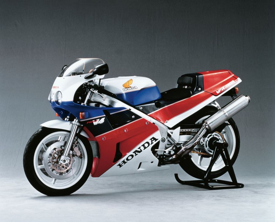 A white-red-blue-and-black 1988 Honda VFR750R RC30 on a rear-wheel stand