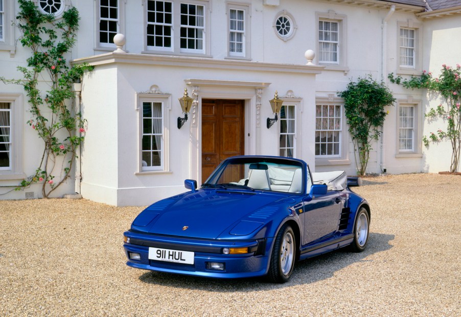 A royal-blue 1989 Porsche 911 Turbo SE Cabriolet parked in front of an ornate white building