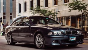 A blue-gray 2000 BMW E39 M5 on a city street